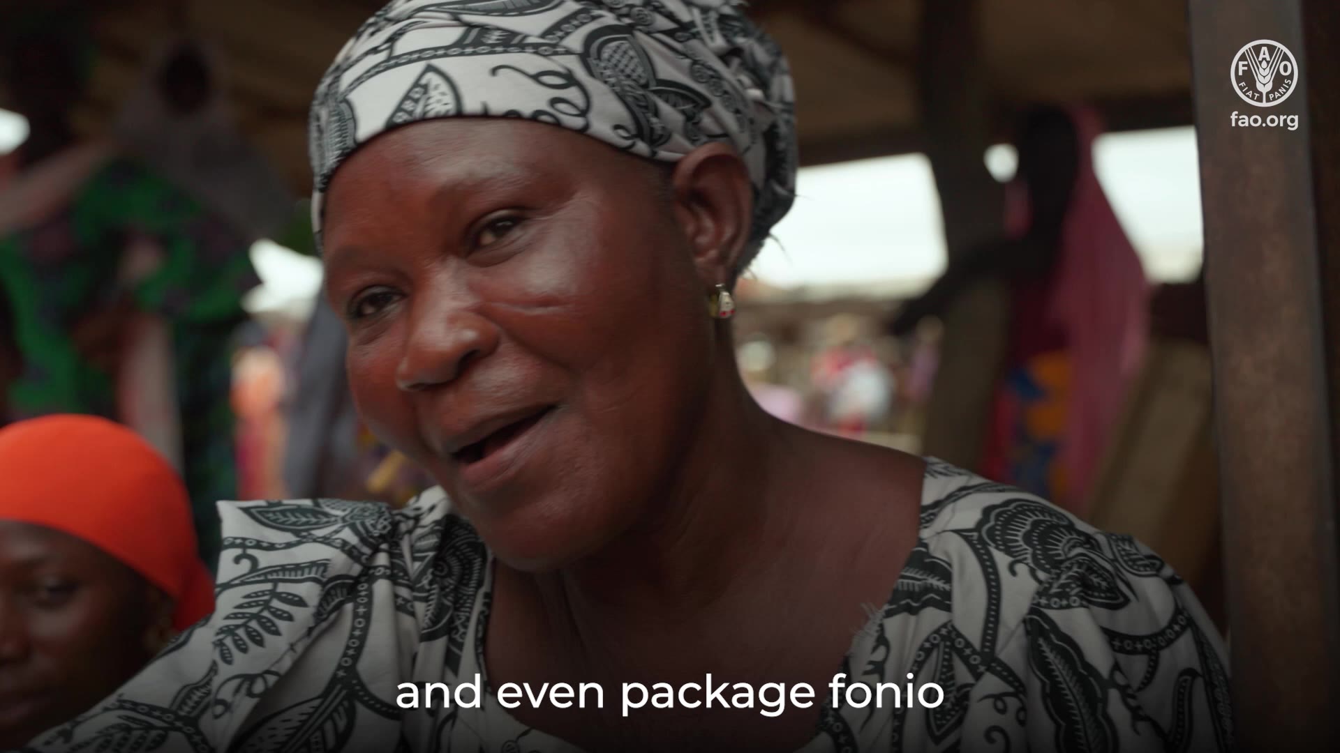 A woman fonio farmer in Cherreponi, Ghana, speaking to camera in a green field